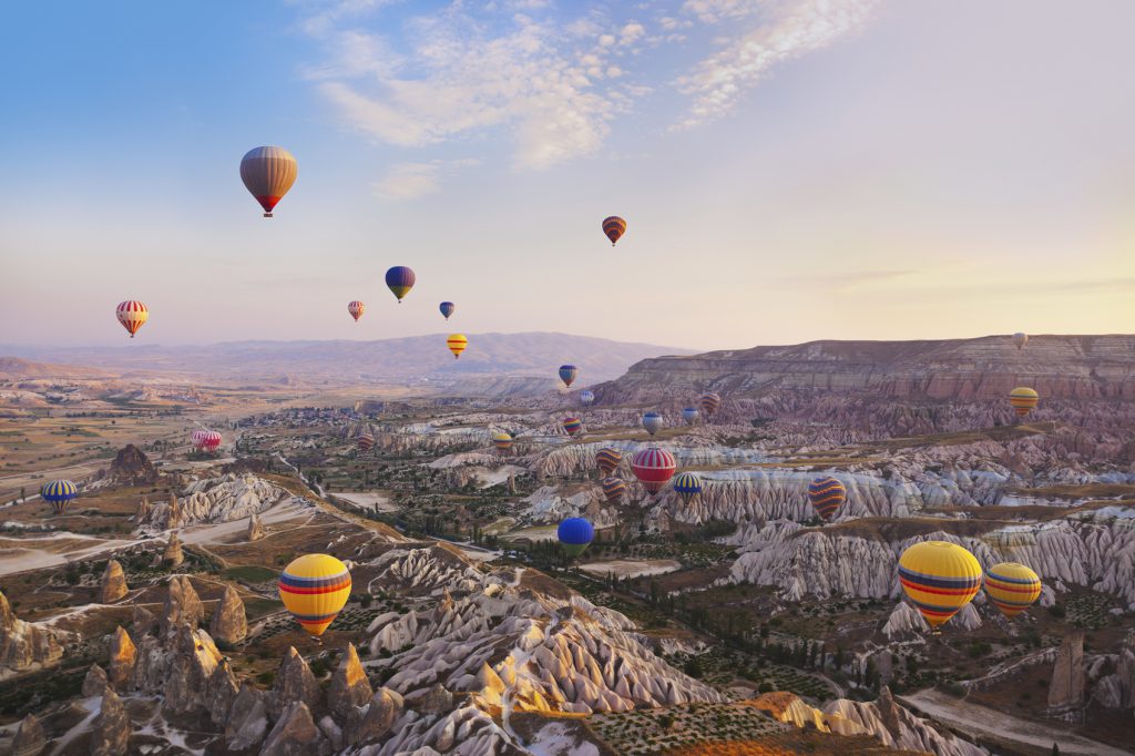 Hot air balloon flying over rock landscape at Cappadocia Turkey