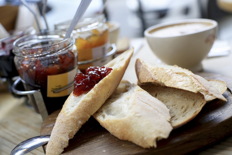 Breakfast, three jars of jam and sliced bread