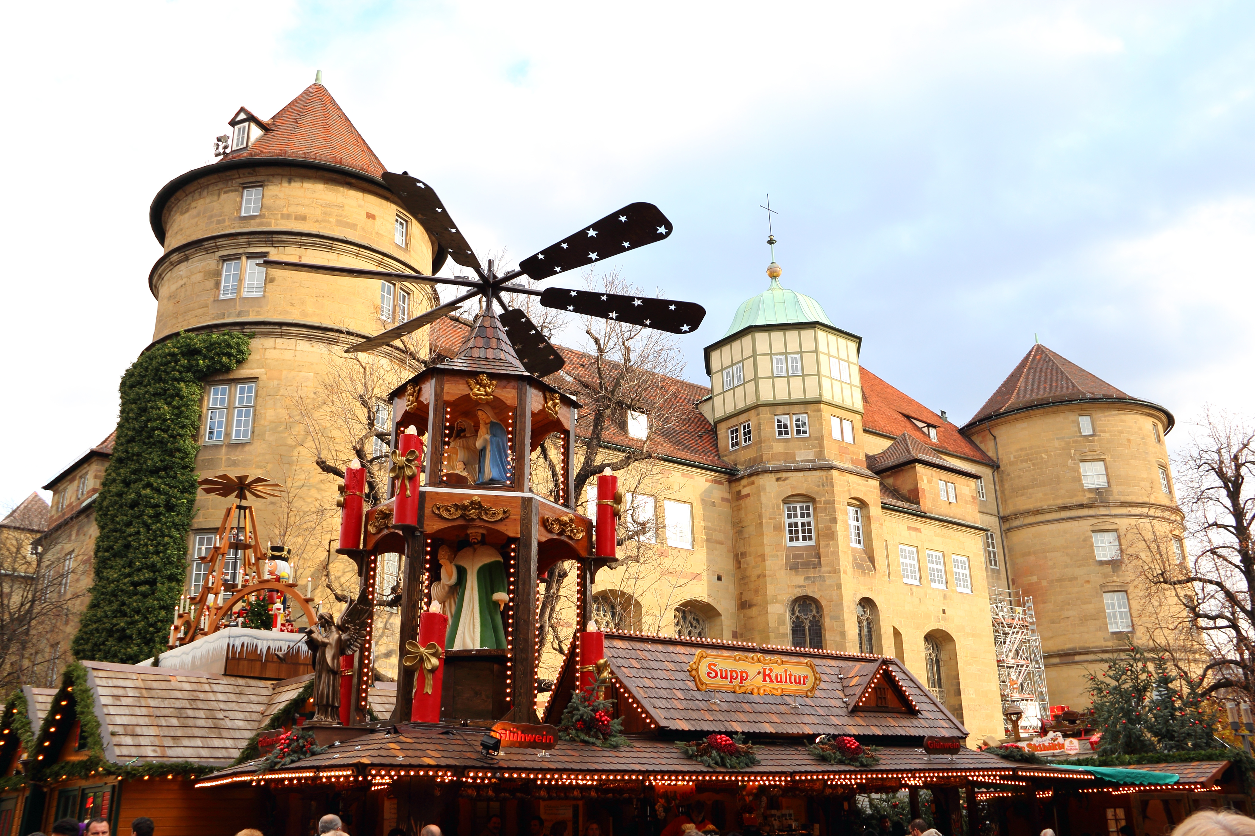 "Stuttgart, Germany - December 2, 2011: Christmas market in Stuttgart. In the foreground, a large illuminated Christmas pyramid with serving hot drinks and delicious soups. In the background is the Old Palace / National Museum (Altes Schloss/Landesmuseum)."